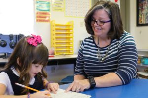 Teacher working with young girl at Calvary Christian School