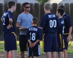 Flag football coach talking with Calvary Christian School boy's flag football team