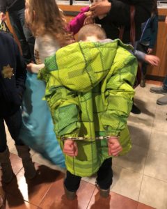 Young boy with a green coat at police officer assembly