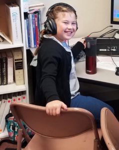 Girl with headphones listening to the computer at Calvary Christian School